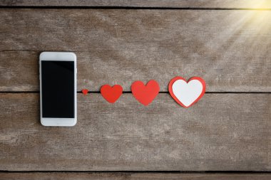 Smartphone ve hearts Kağıt ahşap arka plan üzerinde