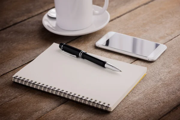 Xícara de café, notebook, caneta e telefone inteligente — Fotografia de Stock