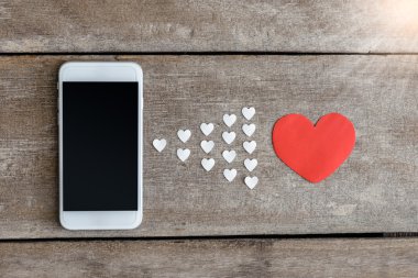 Smartphone ve hearts Kağıt ahşap arka plan üzerinde