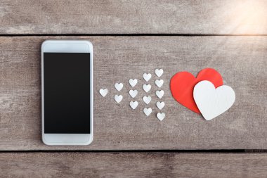 Smartphone ve hearts Kağıt ahşap arka plan üzerinde