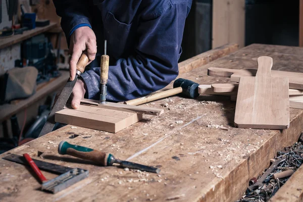 Carpintero trabajando en un tablero de corte de madera con un archivo —  Fotos de Stock