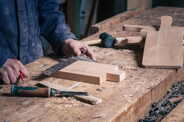 Carpintero trabajando en una tabla de cortar de madera con lápiz y regla —  Fotos de Stock