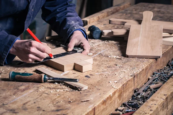 Carpintero trabajando en una tabla de cortar de madera con lápiz y regla —  Fotos de Stock