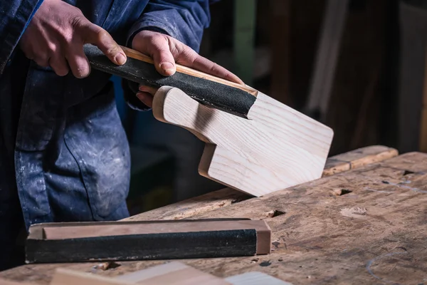 Carpintero lijado pieza de madera con papel de lija — Foto de Stock