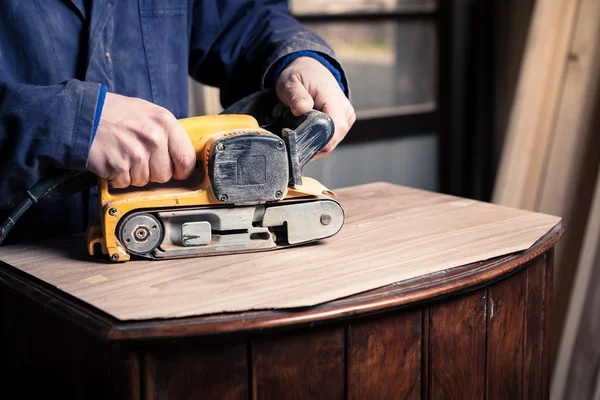 Mobília de restauração de carpinteiro com lixadeira de cinto — Fotografia de Stock