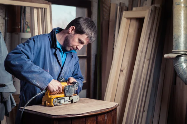 Carpenter restoring furniture with belt sander — Stock Photo, Image