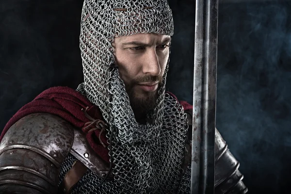 Middeleeuwse krijger met maliënkolder, harnas en rode mantel — Stockfoto
