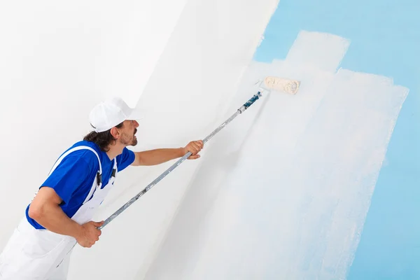 Schilder schilderij een muur met verfroller — Stockfoto