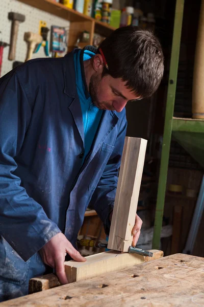 Tesaře pracujícího na Dřevěná prkna s svěrák — Stock fotografie