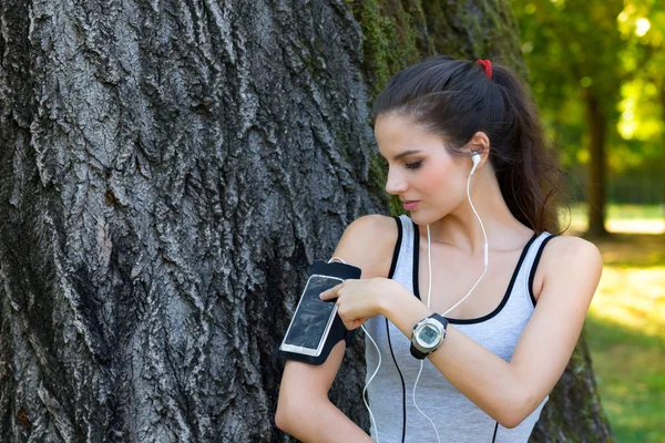 Female runner settings smart phone in armband — Stock Photo, Image