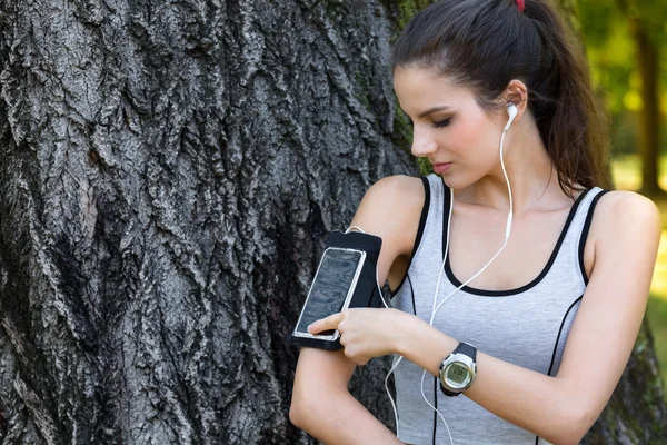 Läuferin stellt Smartphone in Armbinde ein — Stockfoto