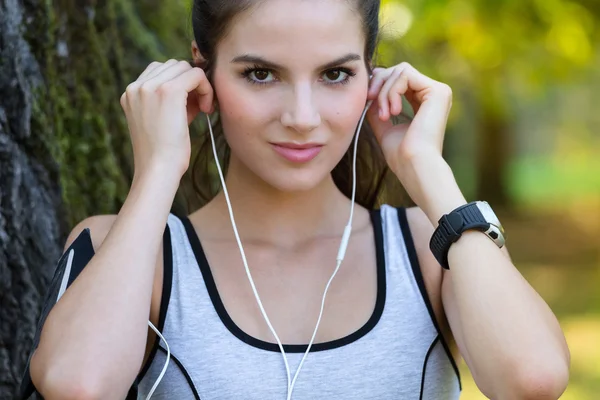 S úsměvem mladá žena na sobě sluchátka — Stock fotografie