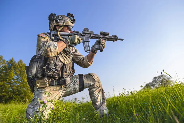 Soldado americano apuntando su rifle sobre el fondo azul del cielo — Foto de Stock