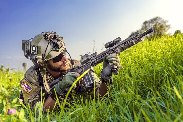 Amerikanischer Soldat richtet sein Gewehr auf blauem Himmel — Stockfoto