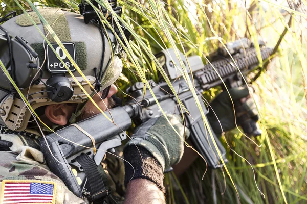 Soldado americano apontando seu rifle na grama — Fotografia de Stock