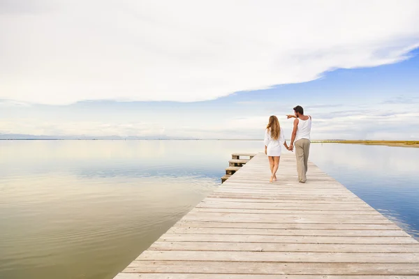 Casal caminhando e apontando para o horizonte — Fotografia de Stock