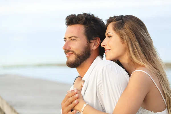 Donna che abbraccia il suo uomo da dietro sullo sfondo del mare — Foto Stock