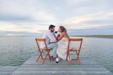 Deniz kenarında kırmızı şarap içme Çift