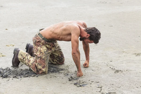 На колінах без сорочки солдат з кулаками на землі — стокове фото