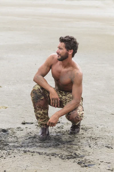 Kneeling Shirtless Soldier on the Beach Sand — Stock Photo, Image