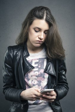 Yüzünde sıkılmış duygu ile telefon seyir yorgun kız