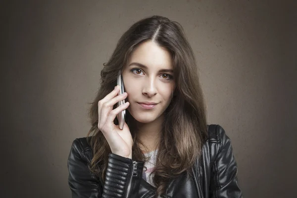 Atractiva chica joven en el teléfono mirando a la cámara en la textura de nuevo —  Fotos de Stock