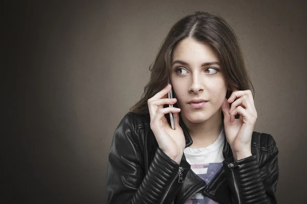 Chica joven atractiva en el teléfono en el fondo de textura . —  Fotos de Stock