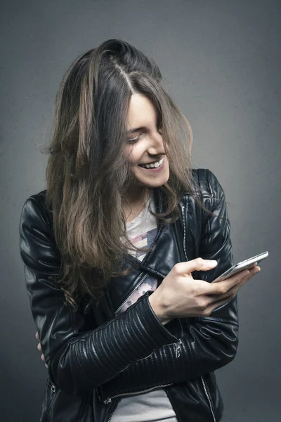 Lachen meisje op zoek naar telefoon met geamuseerd emotie op haar f — Stockfoto