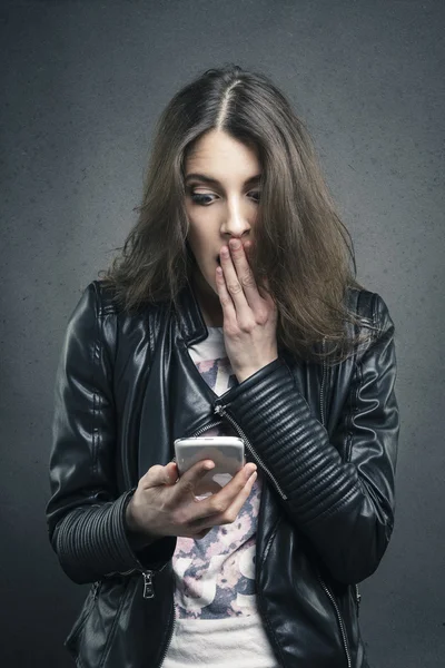 Astonished girl looking at phone with surprised emotion — Stock Photo, Image