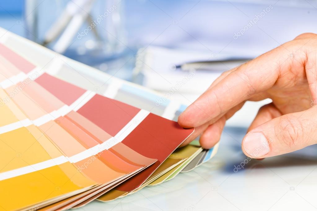 Artist hand browsing color samples in palette