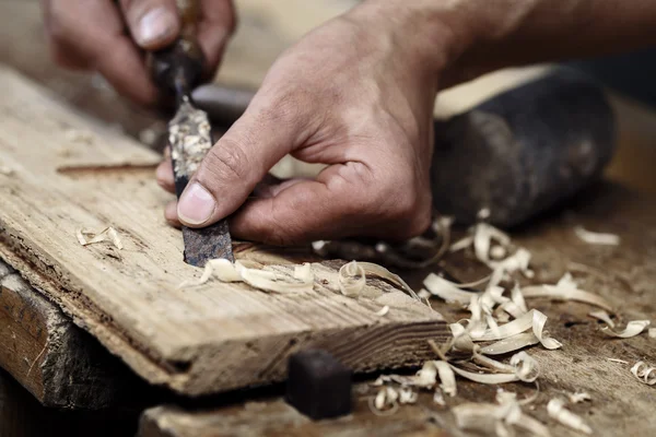 Carpenter hands working with a chisel and carving tools — Stock Photo, Image