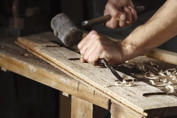 Les mains de menuisier travaillant avec un ciseau et un marteau — Photo