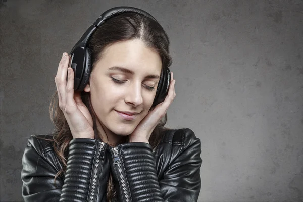 Mujer sonriente con auriculares escuchando música — Foto de Stock