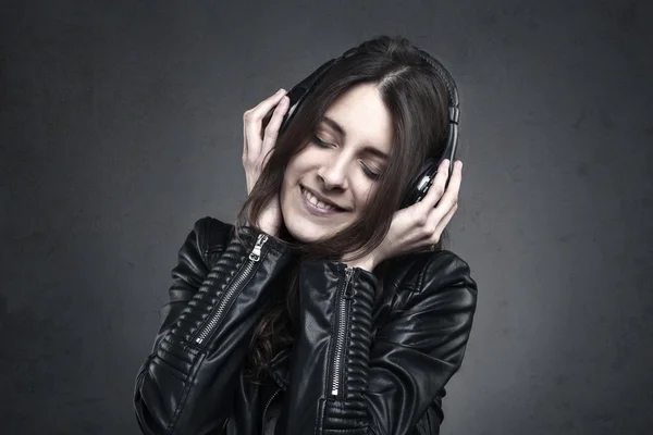 Улыбающаяся женщина с наушниками слушает музыку — стоковое фото