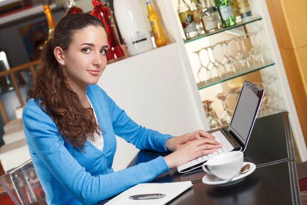 Hermosa chica tomando un café y trabajando en una computadora —  Fotos de Stock