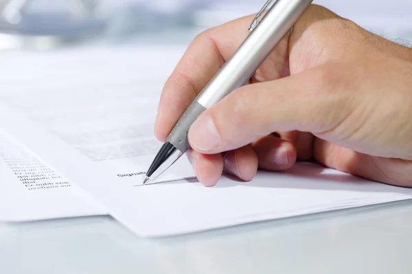 Close-up shot of hand signing a document — Stock Photo, Image