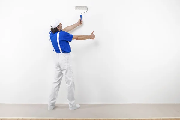 Målare med paintroller gör ok på vit vägg — Stockfoto