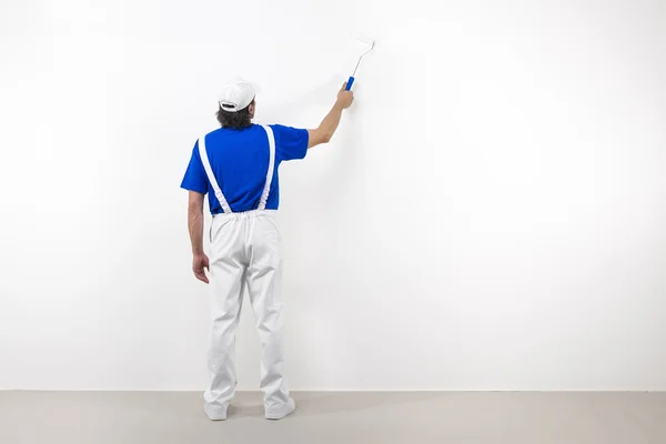 Pintor con pintor en pared blanca — Foto de Stock