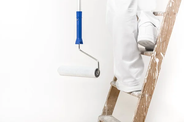 Close up shot of painter man at work climbing a ladder with pain — Stock Photo, Image