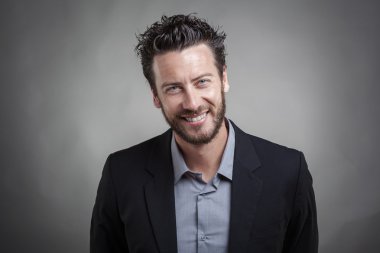 Gri takım elbise giymiş yakışıklı genç