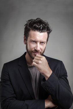 Gri takım elbise giymiş yakışıklı genç