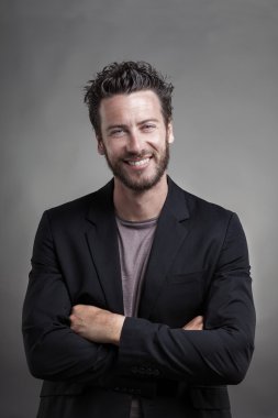 Gri takım elbise giymiş gülümseyen yakışıklı gülümseyen adam