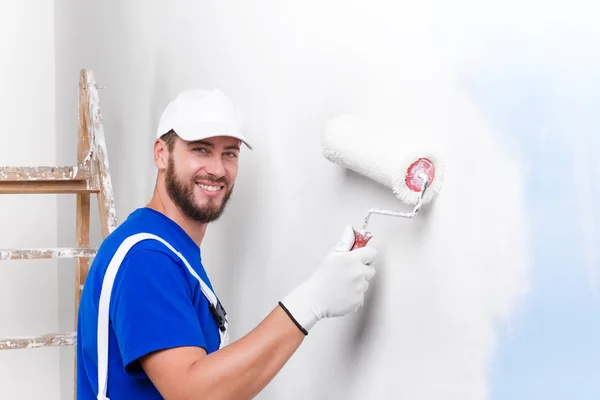 Painter in white dungarees, blue t-shirt — Stock Photo, Image