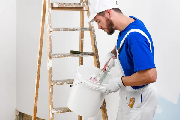 Maler in weißer Latzhose, blauem T-Shirt — Stockfoto