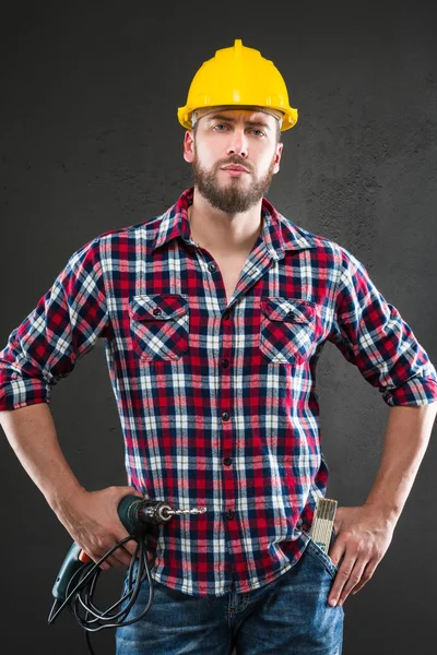Atractivo joven trabajador con taladro — Foto de Stock