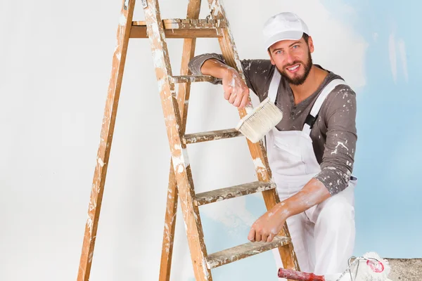 Sonriente pintor guapo con pincel de pintura —  Fotos de Stock