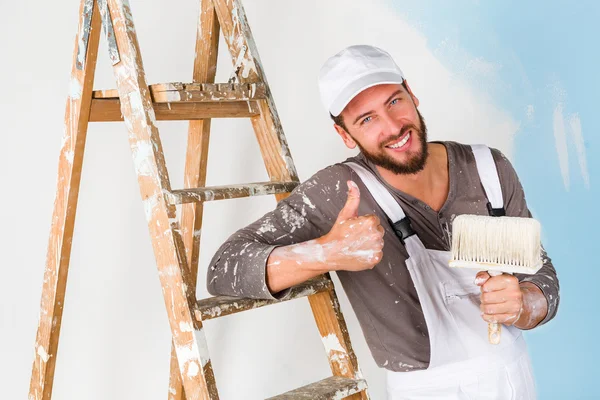 Painter in white dungarees with thumbs up gesture — Stock Photo, Image