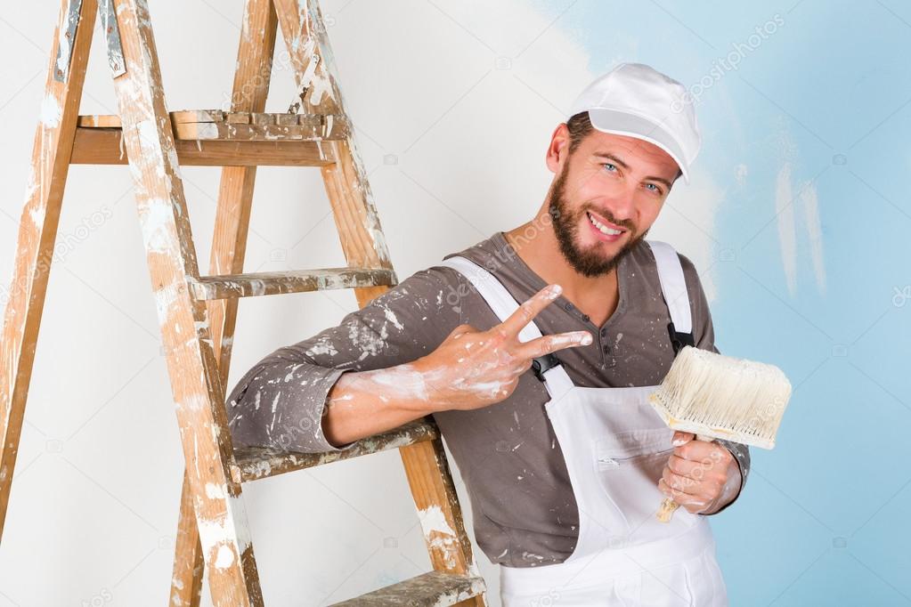 painter in white dungarees with victory gesture