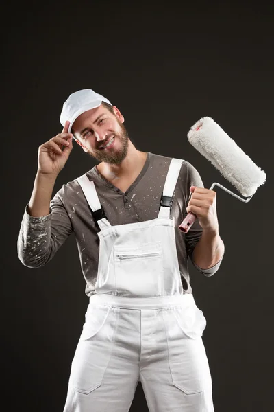 Jovem pintor barbudo atraente com rolo de pintura — Fotografia de Stock