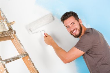 ressam boya yapışan gömlekli bir duvar boyama